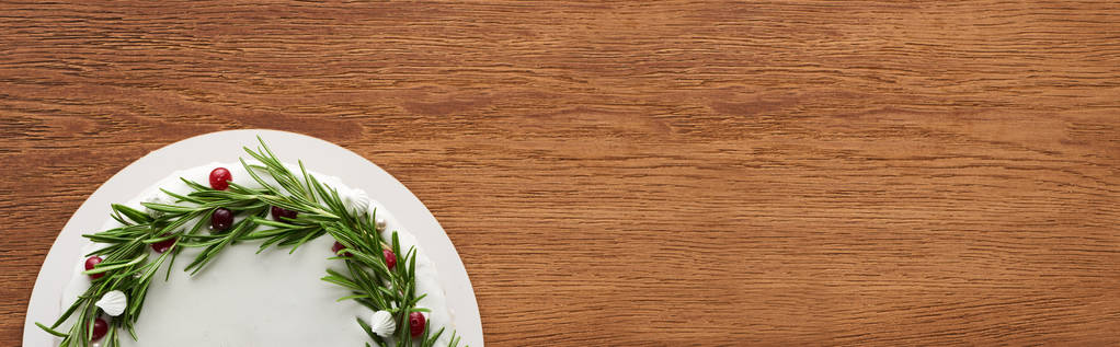 πάνω όψη της χριστουγεννιάτικης πίτας με λευκό κερασάκι, δεντρολίβανο και cranberries σε ξύλινο τραπέζι  - Φωτογραφία, εικόνα