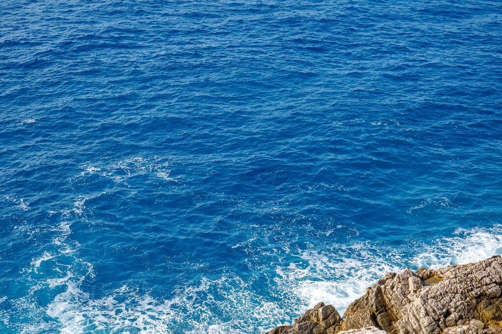 A part menti sziklák tiszta kék vízzel - Fotó, kép