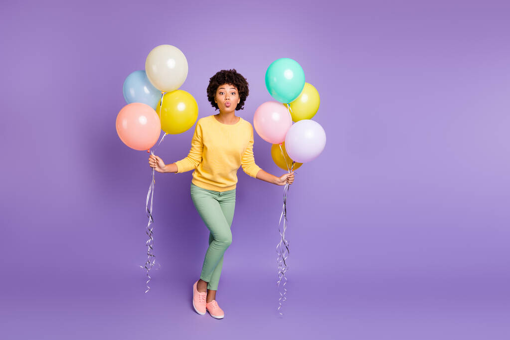 Full body photo of dreamy afro american girl date boyfriend on 14-february holidays get hold baloons send air kisses wear yellow jumper green pants pants isolated fialová barva pozadí - Fotografie, Obrázek