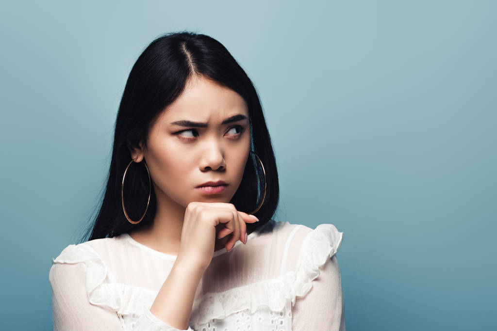 ображена брюнетка азіатська жінка дивиться в сторону на синьому фоні
 - Фото, зображення