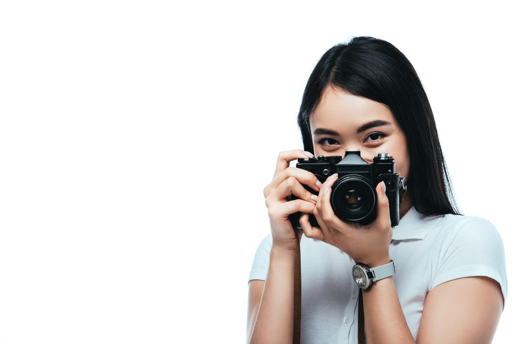 brunette asian woman taking picture on digital camera isolated on white - Photo, Image