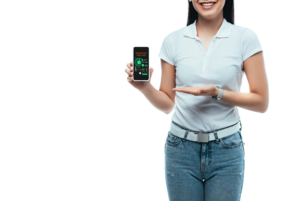 cropped view of happy brunette asian woman presenting smartphone with marketing analysis app isolated on white - Photo, Image
