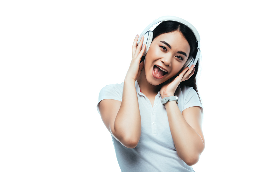 opgewonden aantrekkelijk aziatisch meisje in hoofdtelefoon met open mond geïsoleerd op wit - Foto, afbeelding