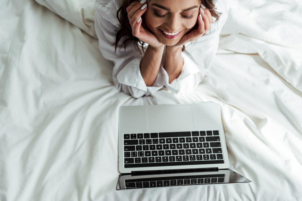 magas szög kilátás mosolygós nő nézi laptop reggel  - Fotó, kép