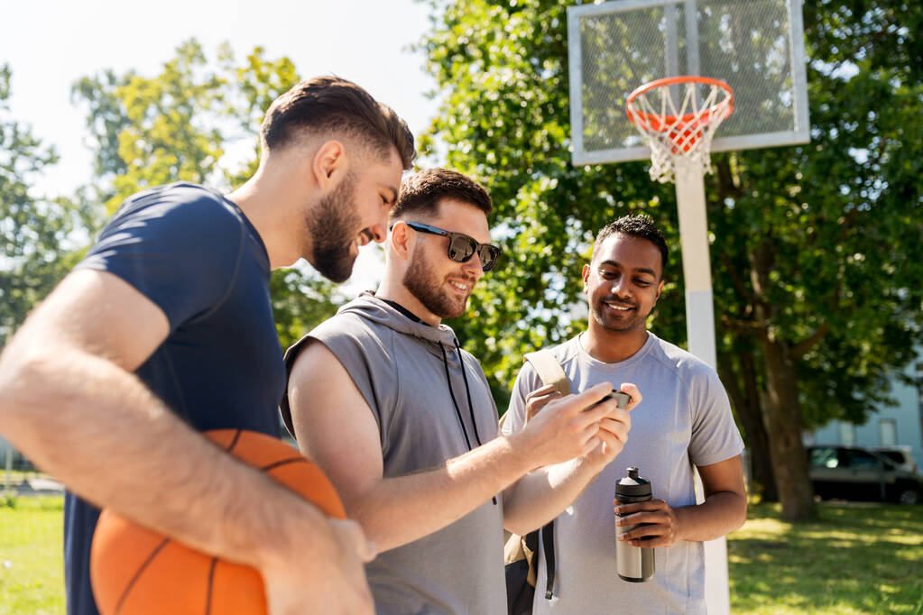 uomini con smartphone al campo da basket
 - Foto, immagini