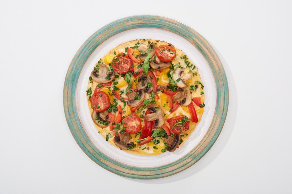 bovenaanzicht van bord met lekkere omelet voor ontbijt op witte tafel - Foto, afbeelding