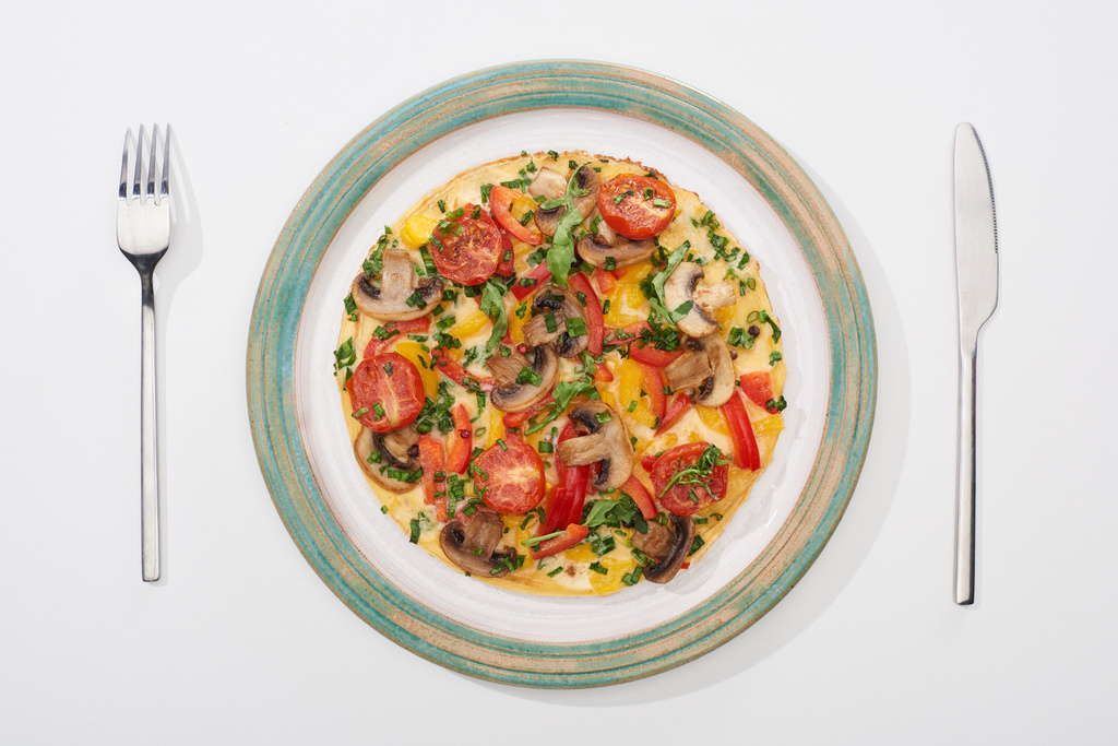 Beyaz masada kahvaltı için lezzetli omletli, domatesli ve mantarlı tabağın üst görüntüsü  - Fotoğraf, Görsel