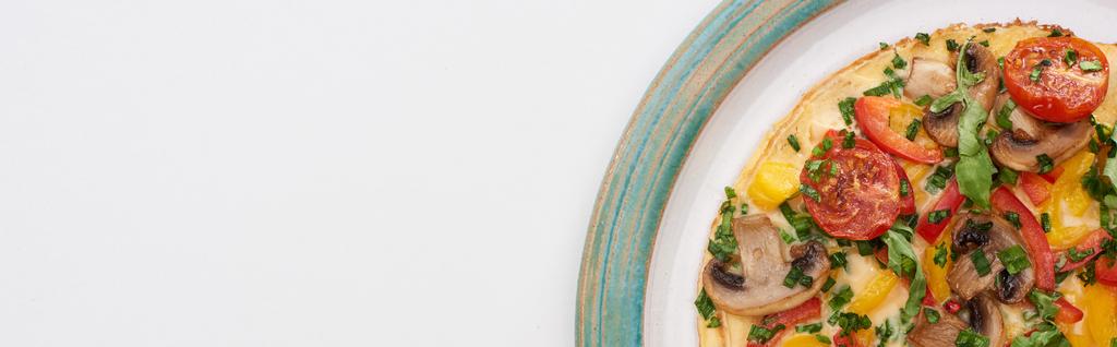 bovenaanzicht van smakelijke omelet met tomaten en champignons voor ontbijt op witte tafel  - Foto, afbeelding