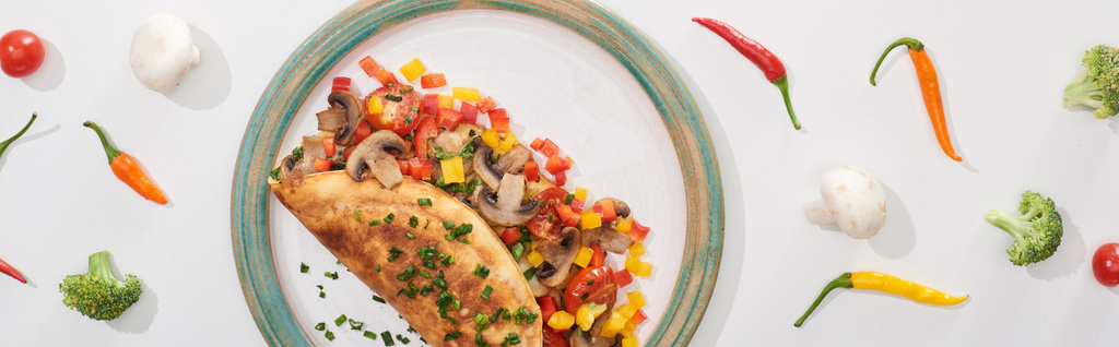 vista superior de la deliciosa tortilla envuelta con verduras en el plato con ingredientes
 - Foto, Imagen