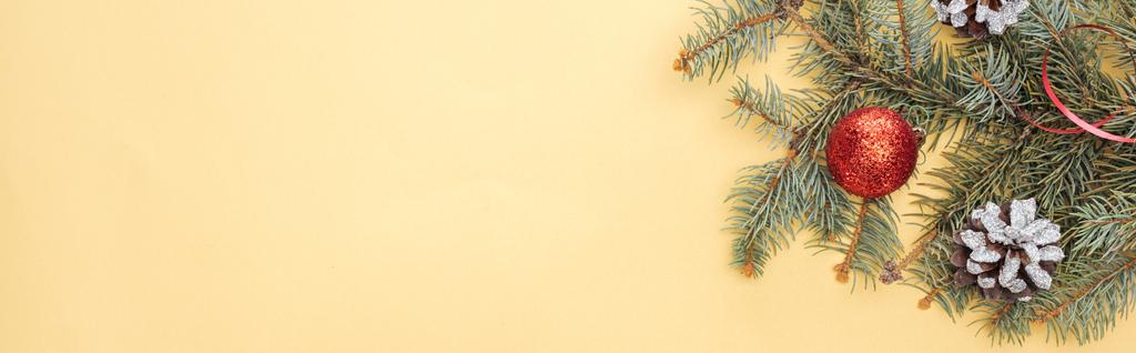 top view of christmas tree branch with bauble on yellow background, panoramic shot - Photo, Image