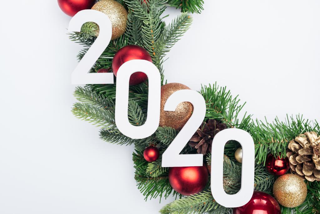 白い背景のクリスマスツリーの花輪の2020年の数字のトップビュー - 写真・画像