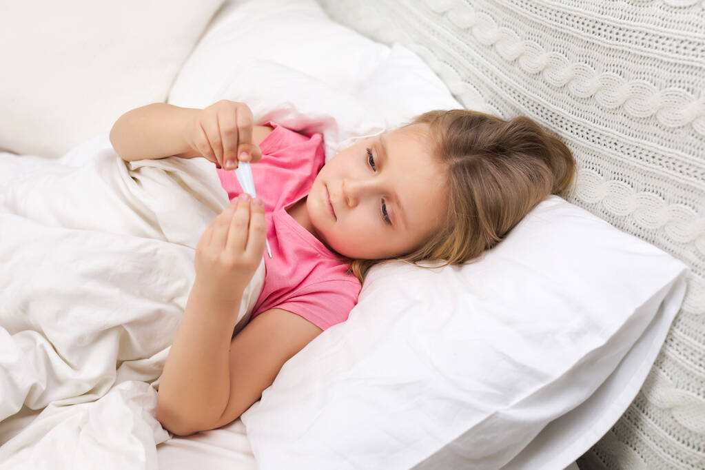 Sick little girl lying in bed with thermometer - Photo, Image