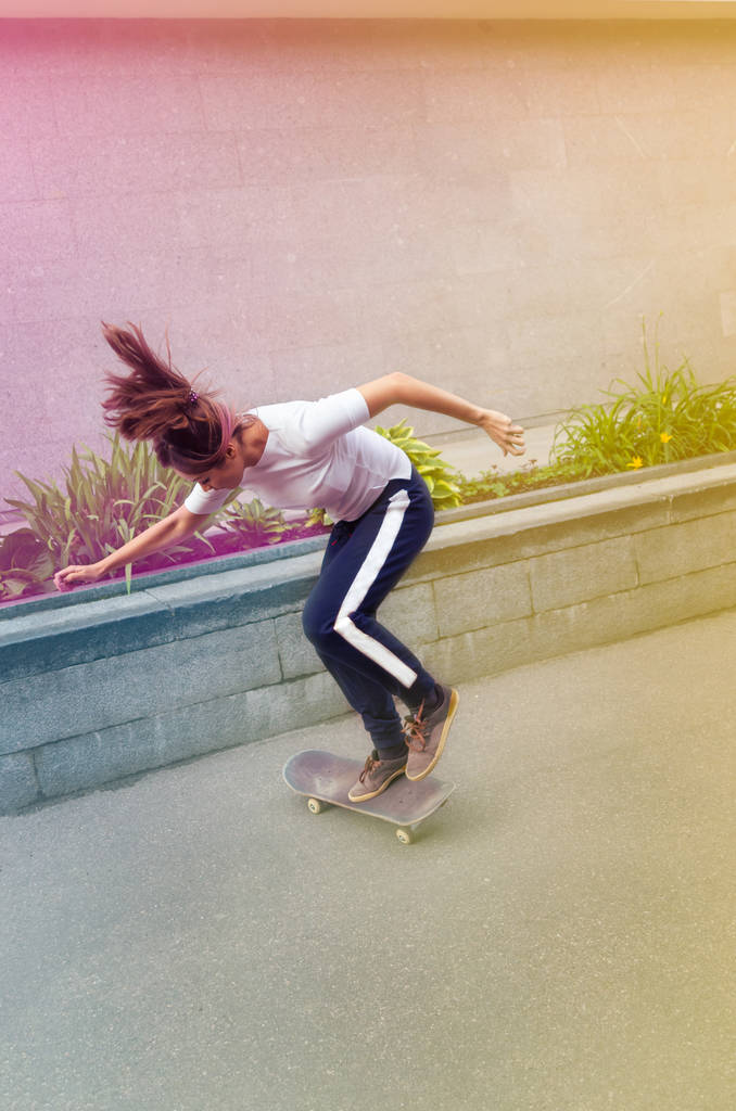 Una bella ragazza skater che esegue un trucco all'aperto. Potere delle donne
. - Foto, immagini