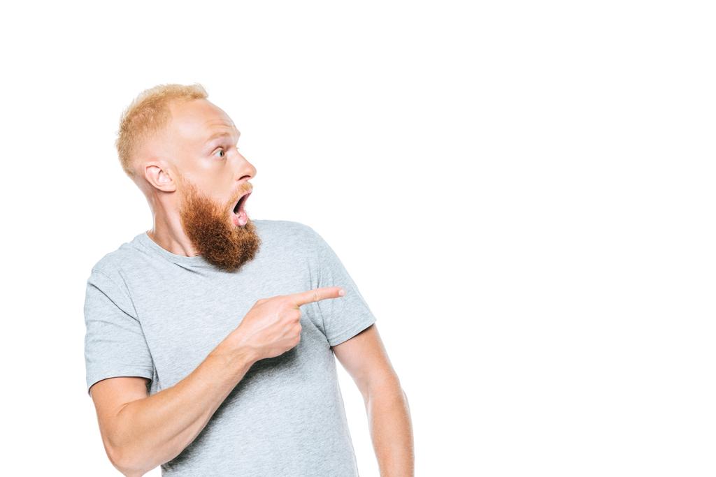 шокированный бородатый мужчина в серой футболке, указывающий изолированным на белом
 - Фото, изображение