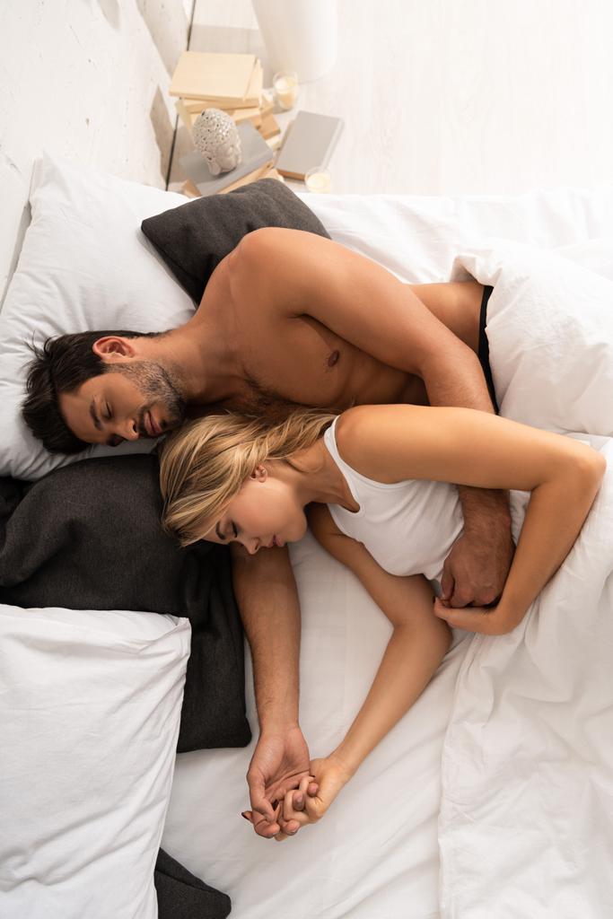 top view of beautiful couple hugging and sleeping in bed in the morning  - Photo, Image