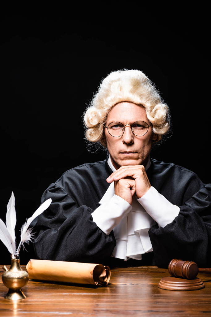 serious judge in judicial robe and wig looking at camera isolated on black - Photo, Image