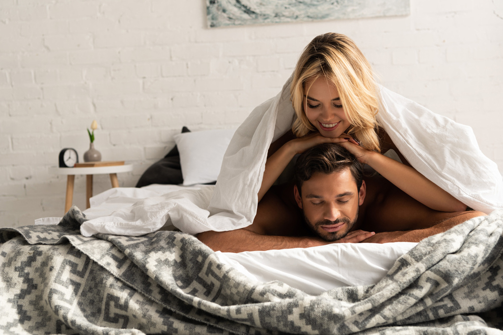 hermosa pareja acostada bajo sábanas por la mañana
  - Foto, imagen