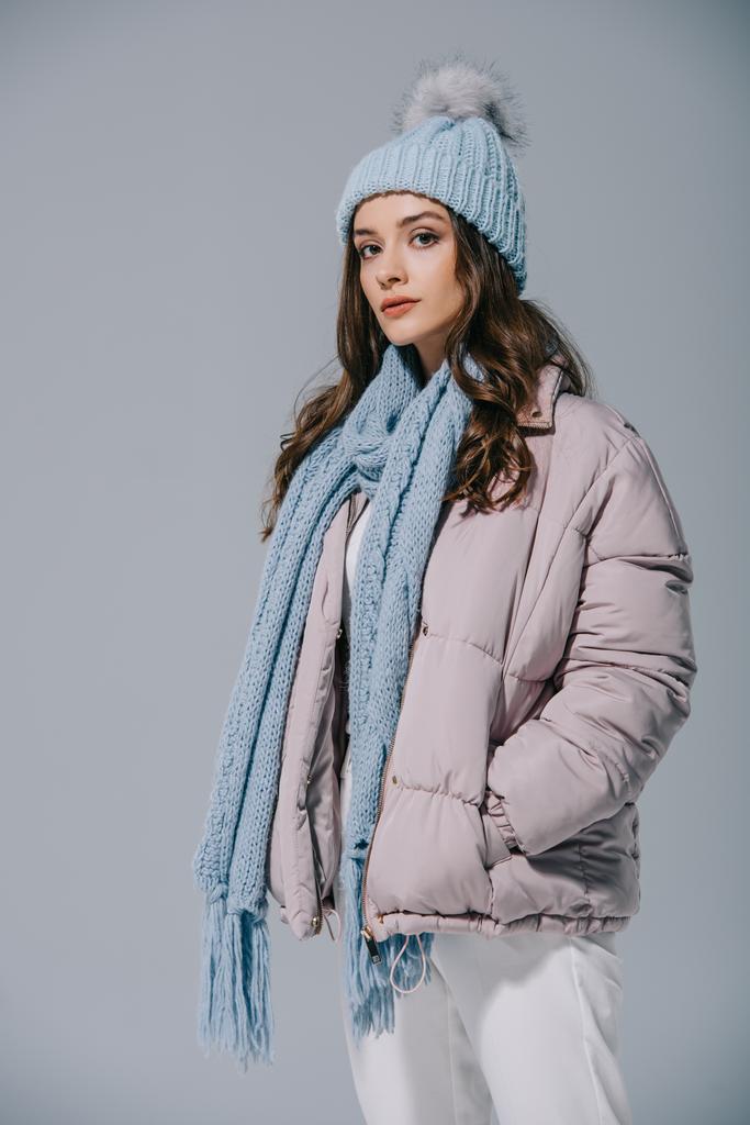 belle fille à la mode posant en manteau chaud, bonnet tricoté et écharpe, isolé sur gris
 - Photo, image