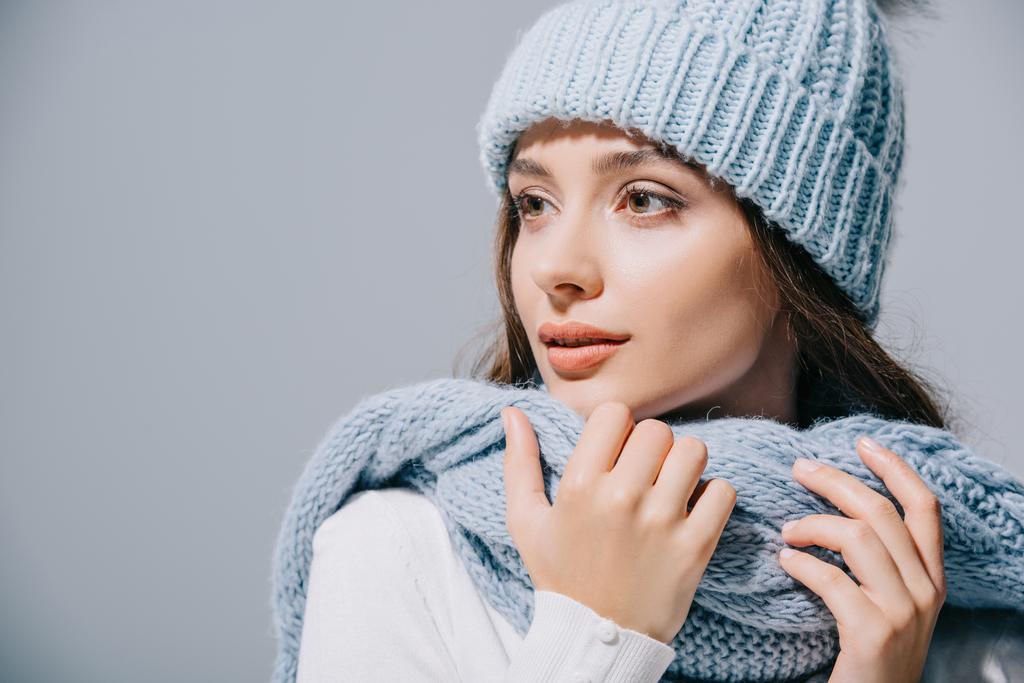 beautiful tender girl posing in blue knitted hat and scarf, isolated on grey - Photo, Image