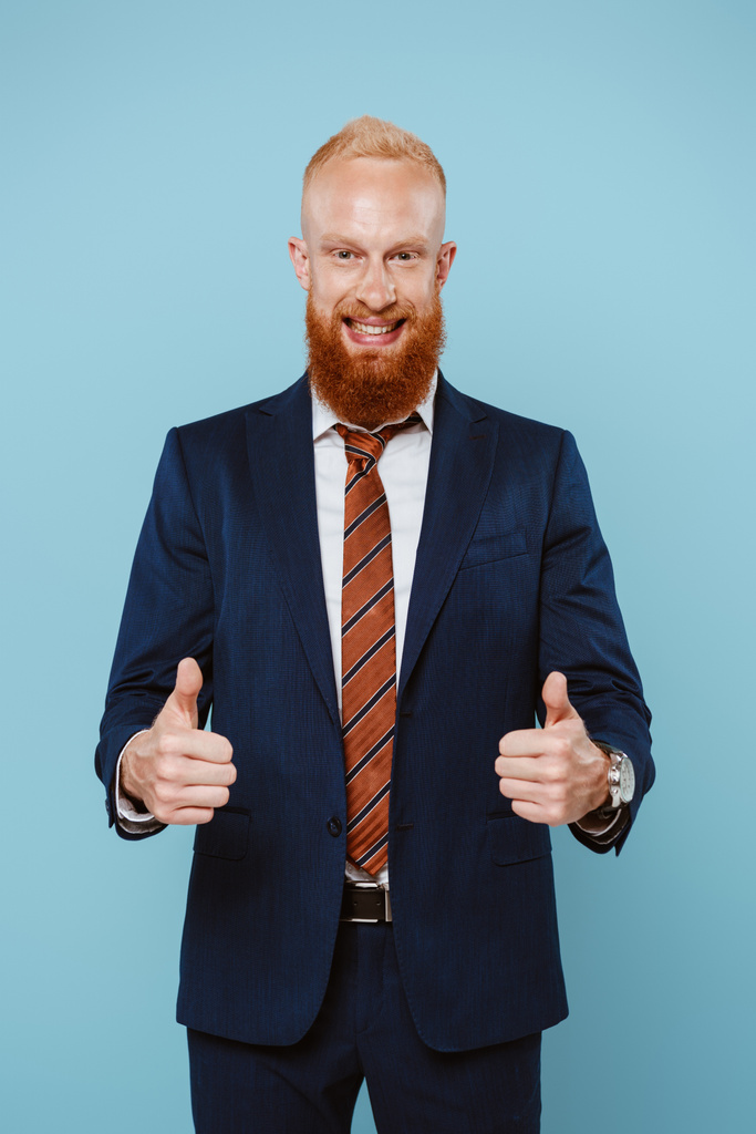 uomo d'affari barbuto sorridente in giacca e cravatta mostrando pollici in su, isolato su blu
 - Foto, immagini