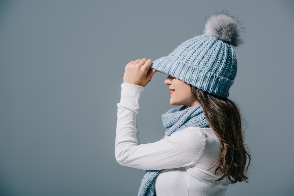 stylish girl posing in knitted hat and scarf, isolated on grey - 写真・画像