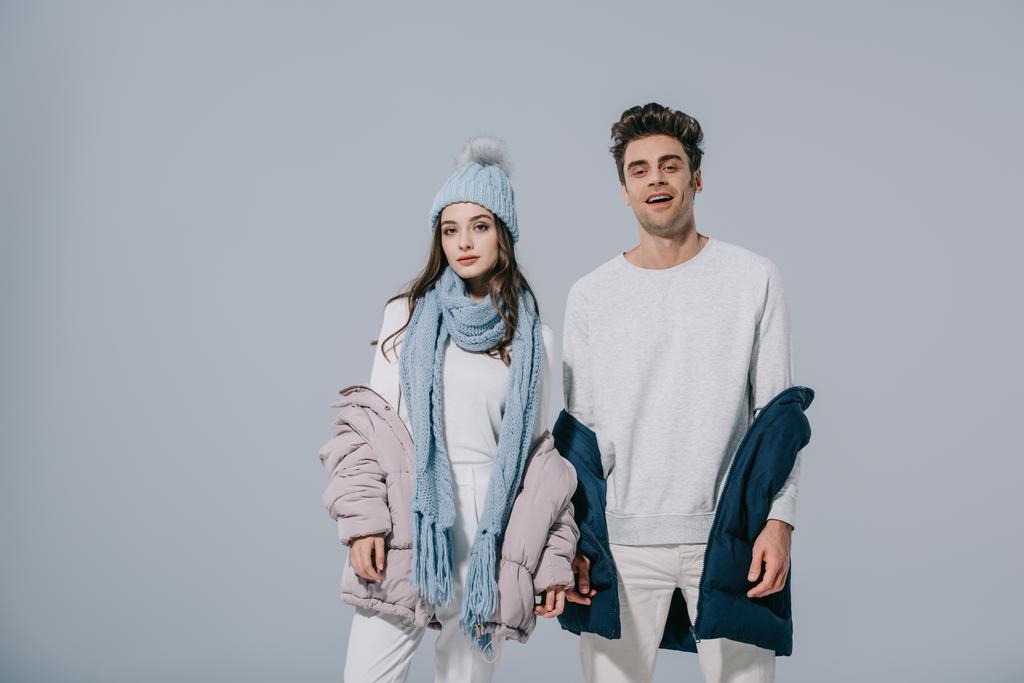 pareja joven de moda posando en traje de invierno, aislado en gris
 - Foto, imagen