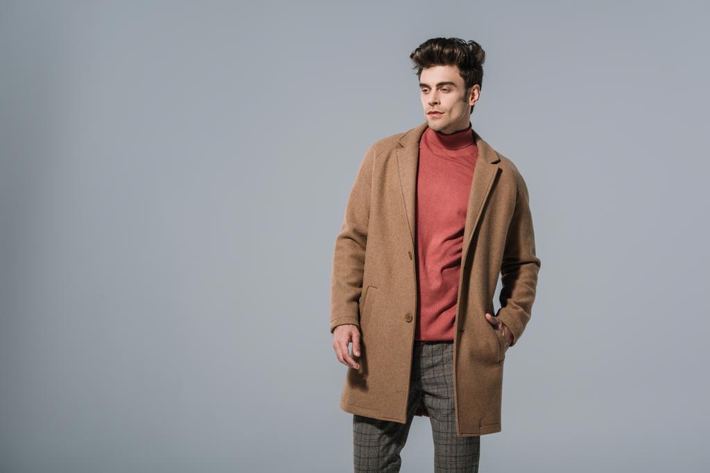 divatos férfi pózol bézs kabát, elszigetelt szürke - Fotó, kép