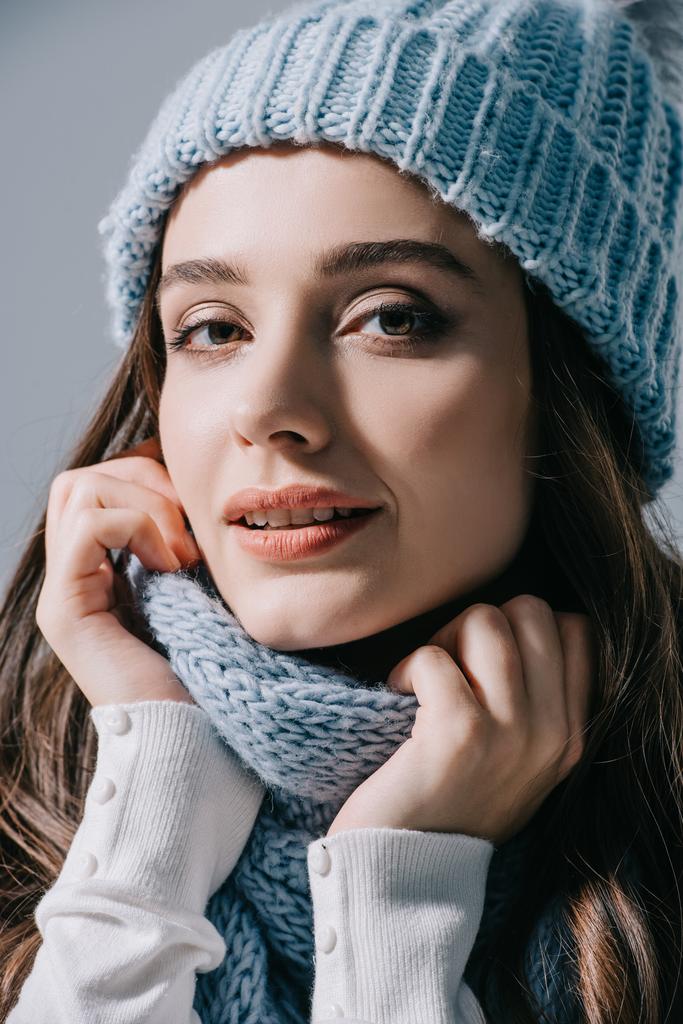 beautiful woman posing in knitted hat and scarf, isolated on grey - Photo, Image