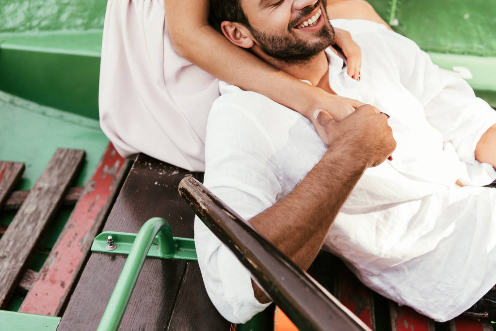 καλλιεργημένη άποψη της νεαρής γυναίκας αγκαλιάζει το φίλο στη βάρκα  - Φωτογραφία, εικόνα