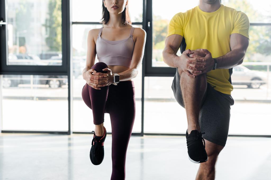 cropped view of sportsman and sportswoman working out together in sports center - Photo, Image