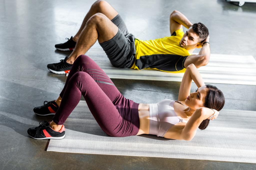 спортсмен і спортсменка роблять перерви на фітнес килимках у спортивному центрі
 - Фото, зображення