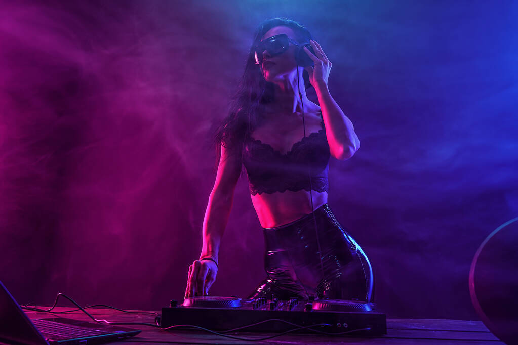 Jeune femme sexy dj jouer de la musique. Casques et mixeur DJ sur la table
. - Photo, image