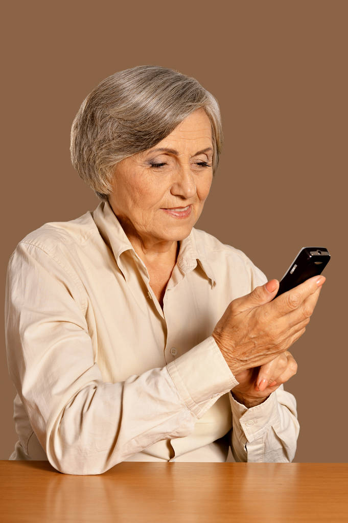 Portrait de belle femme âgée avec téléphone à la maison
 - Photo, image