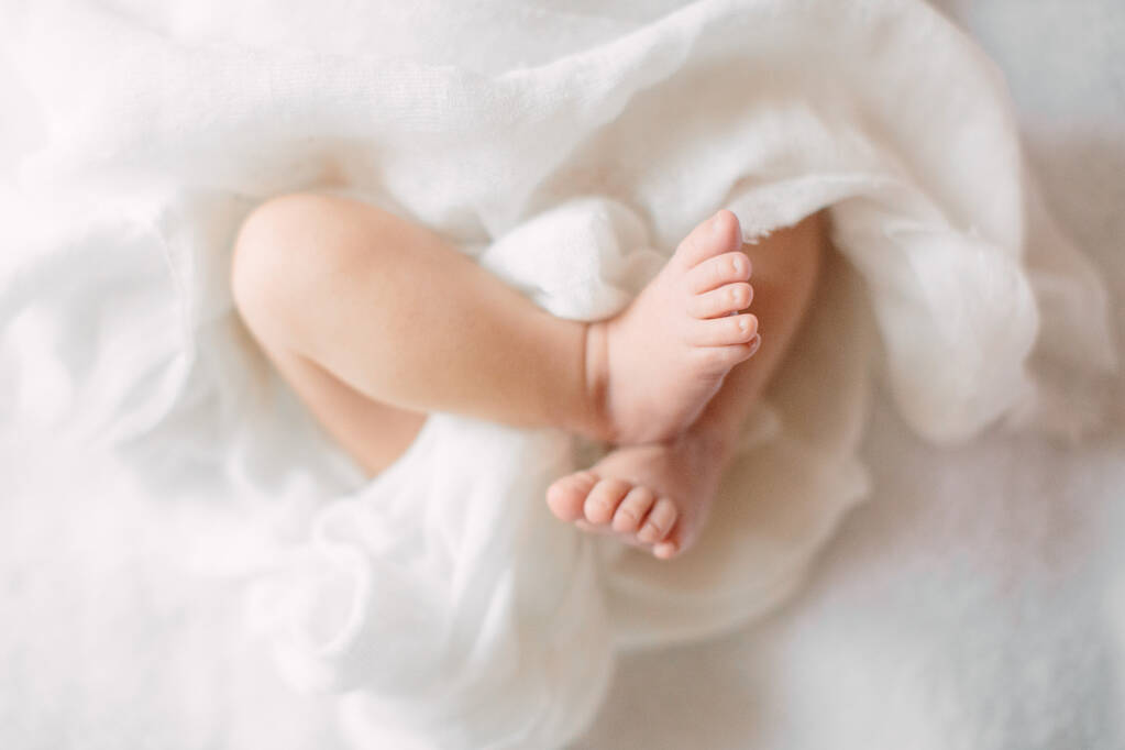 Симпатична новонароджена дівчина спить на пухнастій тканині в білому поясі
 - Фото, зображення
