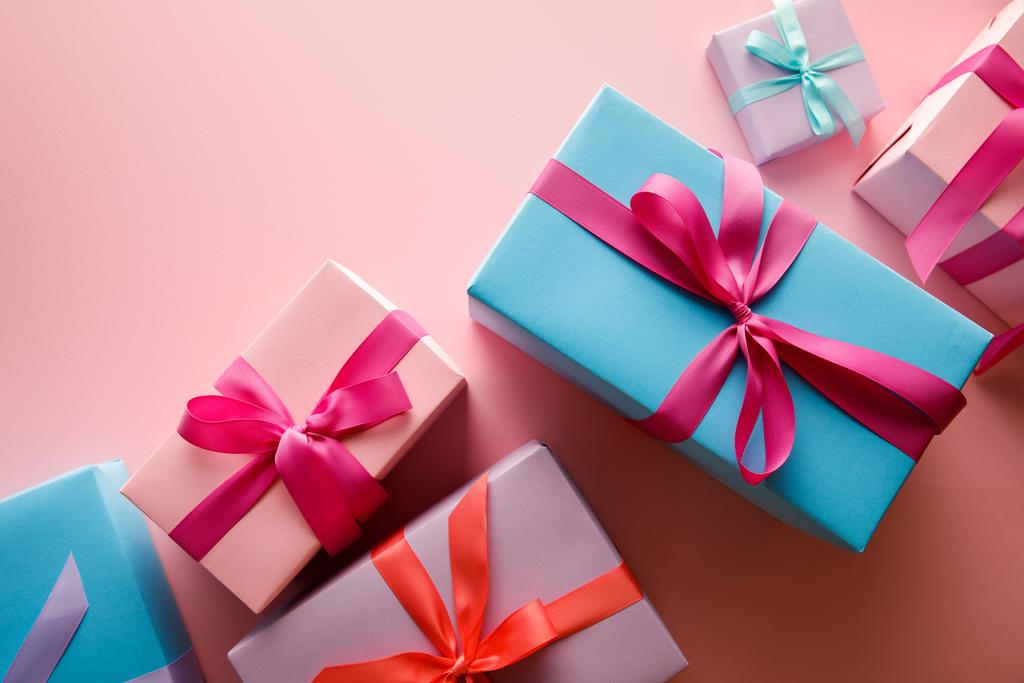 top view of colorful gift boxes with satin ribbons on pink background - Photo, Image