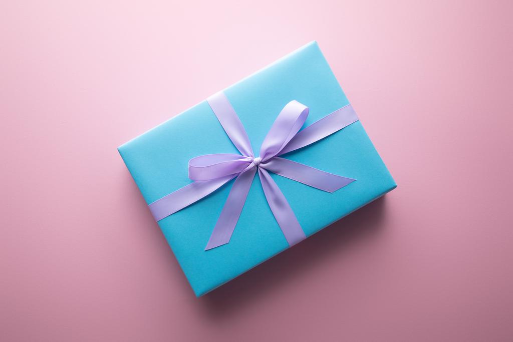 vista superior de la caja de regalo azul con cinta de satén violeta sobre fondo rosa
 - Foto, imagen