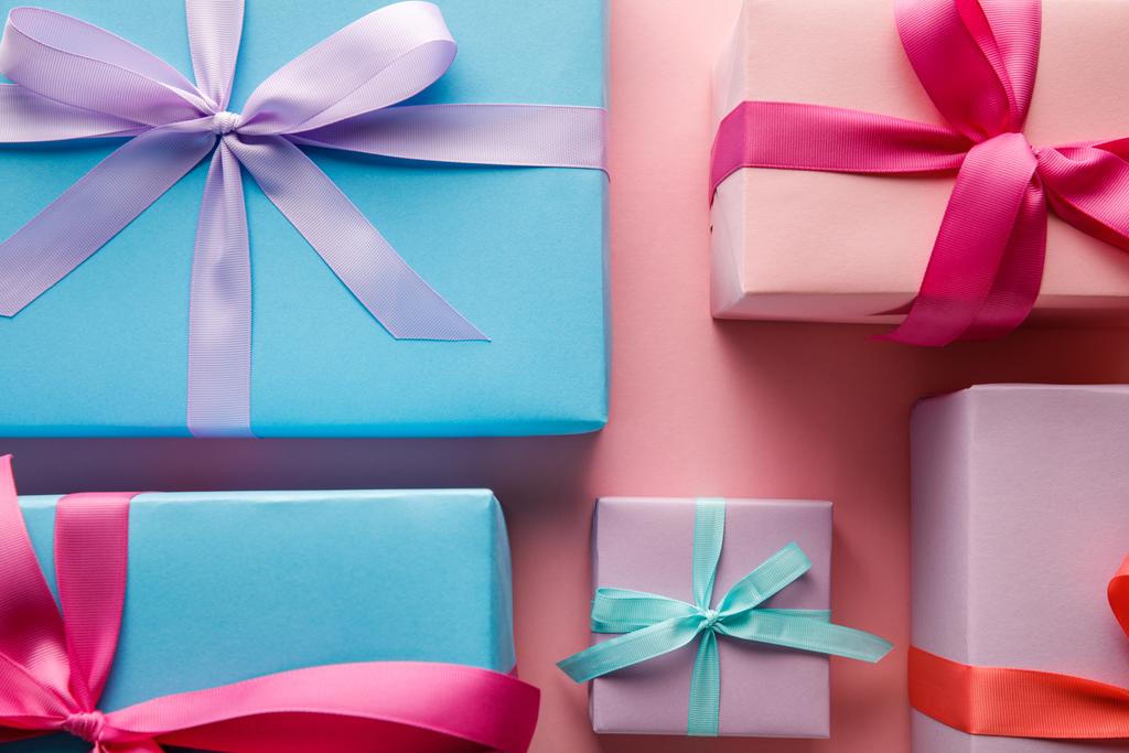 vista superior de coloridas cajas de regalo con cintas sobre fondo rosa
 - Foto, imagen