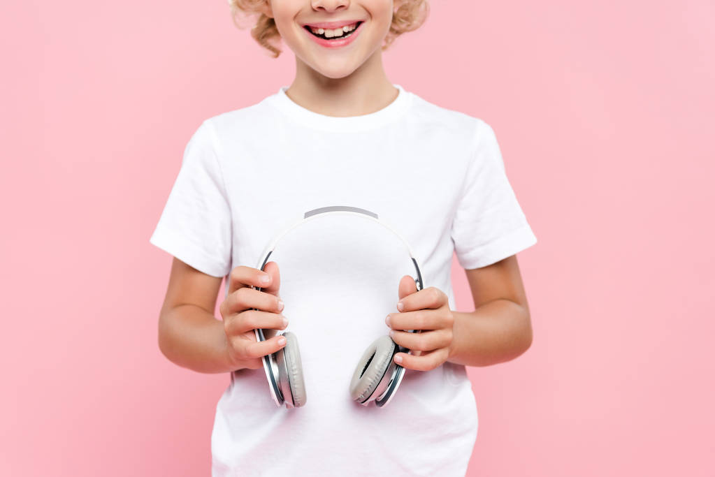 vista ritagliata del bambino sorridente in t-shirt con le cuffie isolate sul rosa
 - Foto, immagini