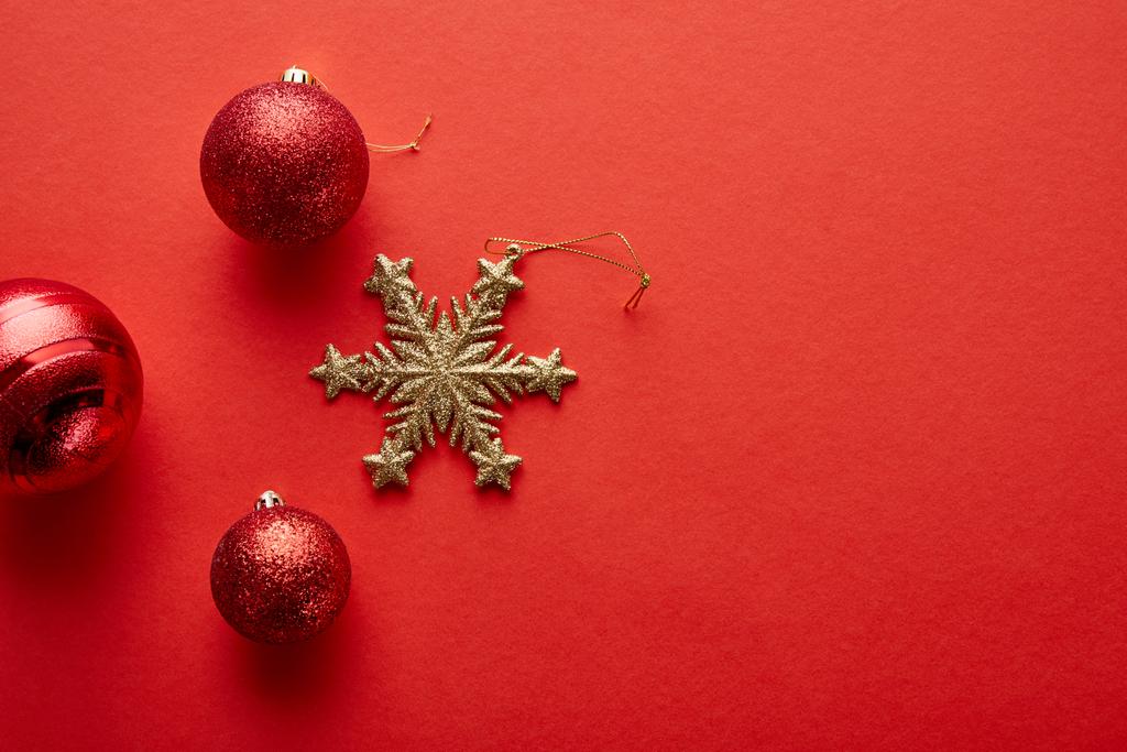 vista superior de brillantes bolas de Navidad y copo de nieve de oro sobre fondo rojo
 - Foto, Imagen
