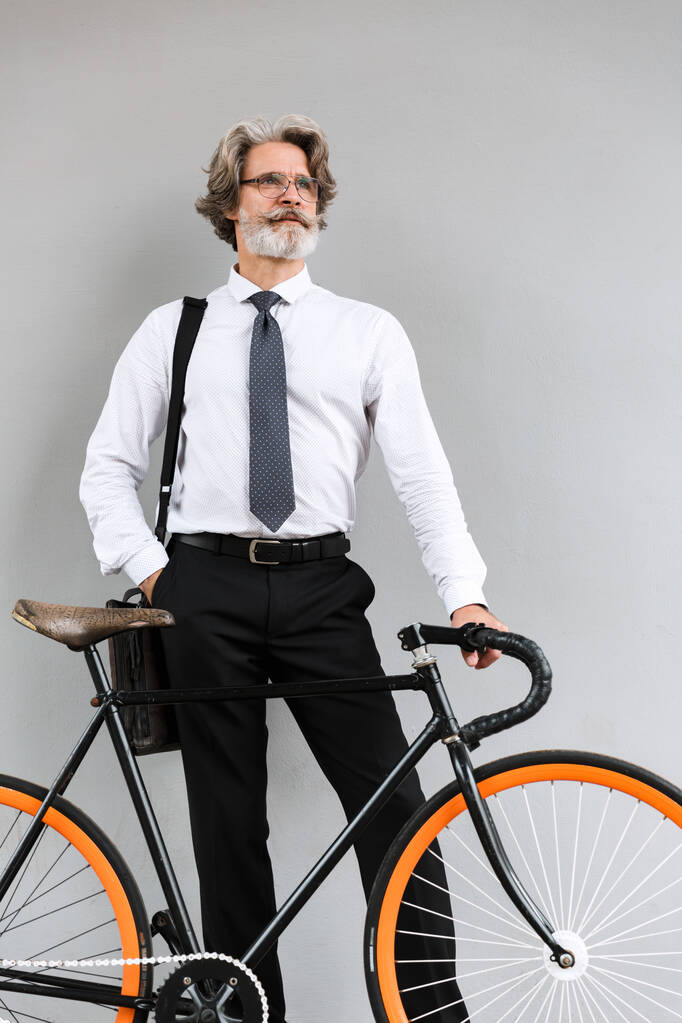 Foto van een knappe oude zakenman met fiets - Foto, afbeelding