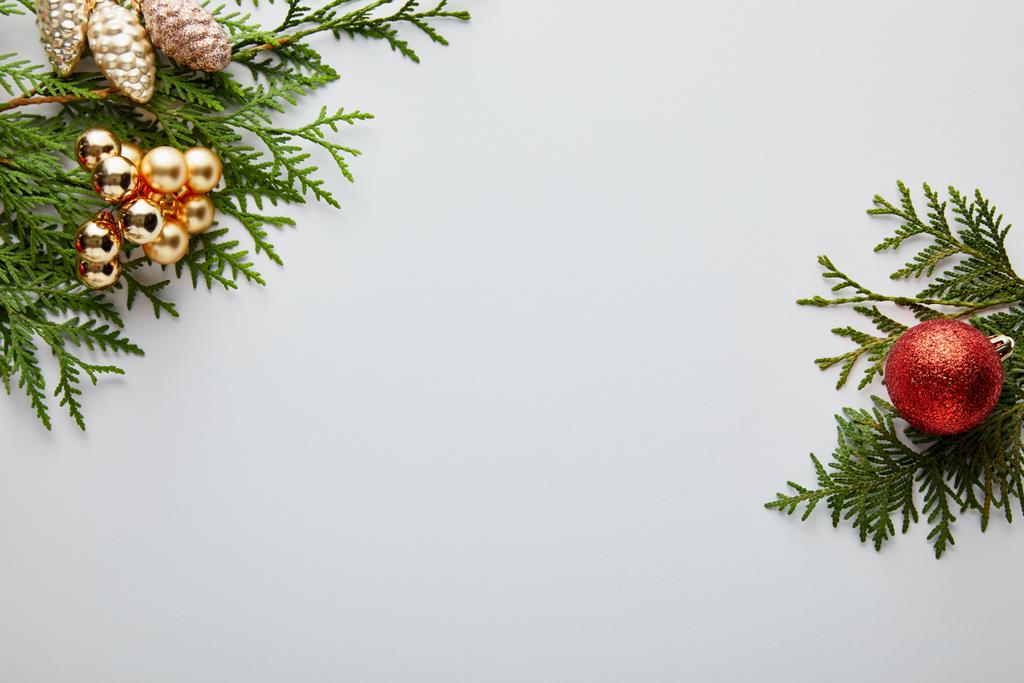 vista superior de la brillante decoración de Navidad dorada y roja en ramas de thuja verde aisladas en blanco con espacio de copia
 - Foto, imagen