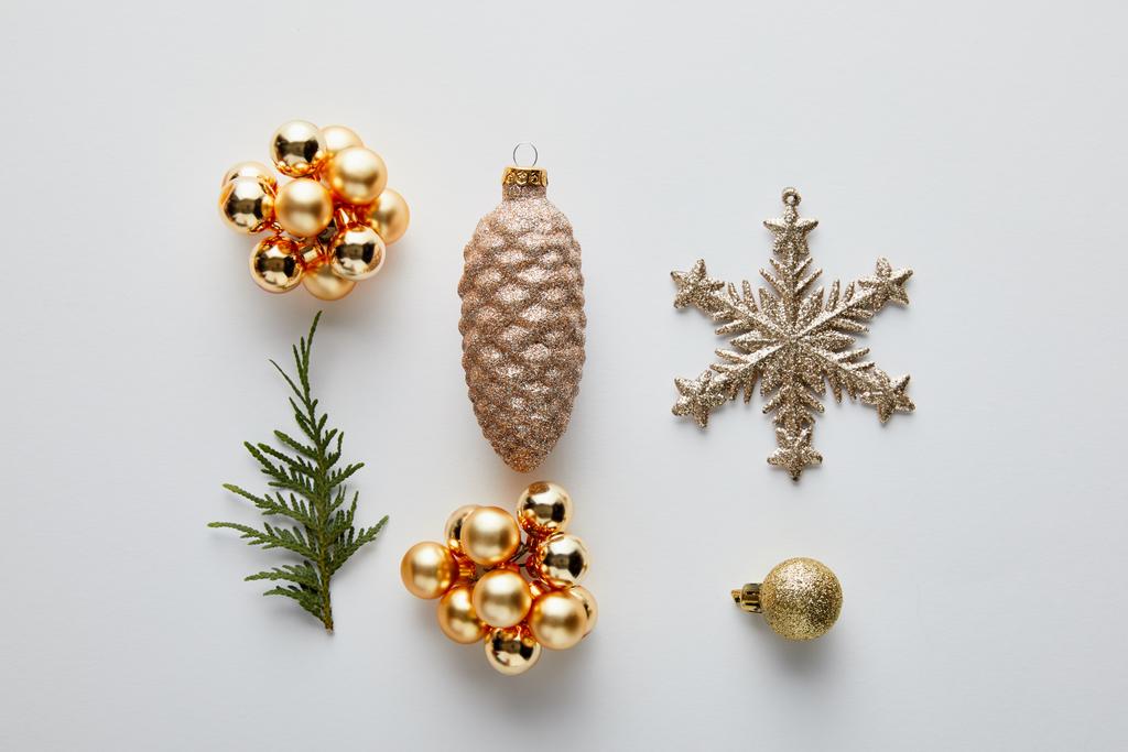 piso con brillante decoración de Navidad dorada y rama de thuja verde aislado en blanco
 - Foto, Imagen