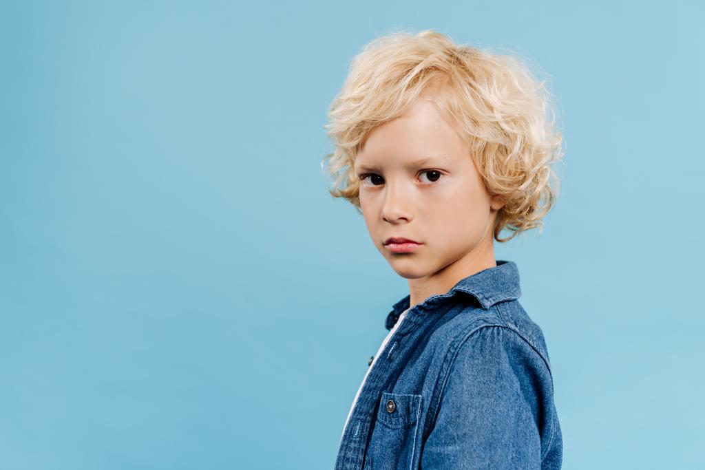 χαριτωμένο και ξανθό παιδί κοιτάζοντας κάμερα απομονωμένη σε μπλε  - Φωτογραφία, εικόνα