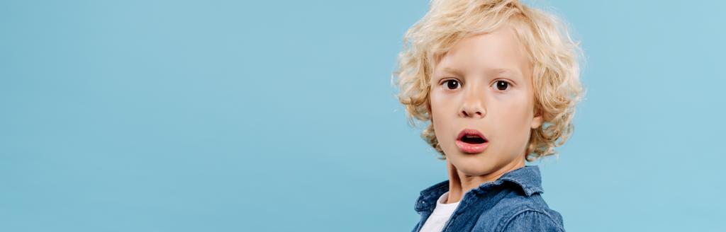 panoramic shot of shocked and cute kid looking at camera isolated on blue  - Photo, Image