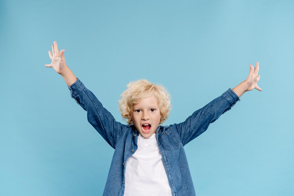 χαρούμενο και χαριτωμένο παιδί με απλωμένα χέρια να ουρλιάζει απομονωμένο στο μπλε  - Φωτογραφία, εικόνα