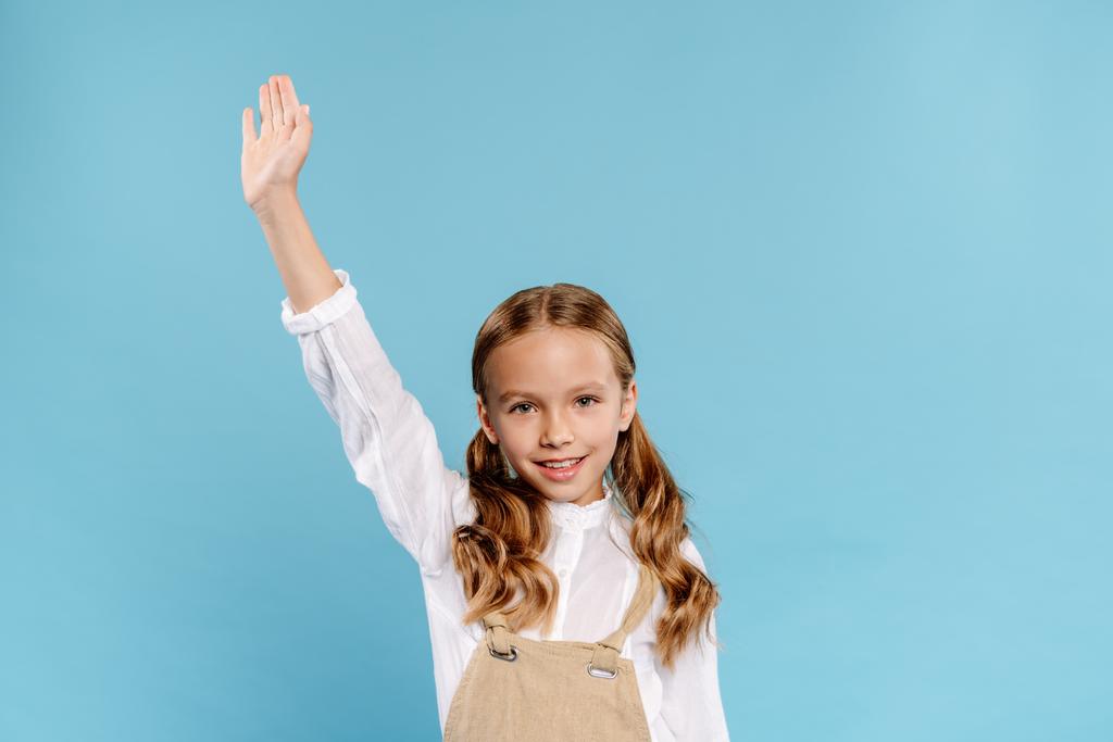 smiling and cute kid with outstretched hand looking at camera isolated on blue  - Photo, Image