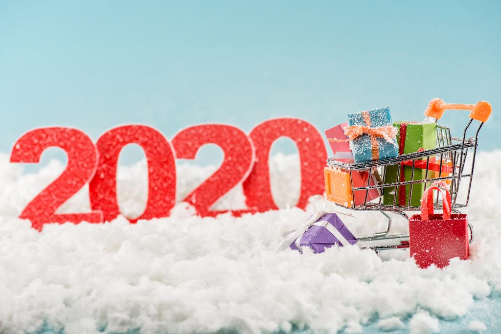 selectieve focus van nummers 2020 en kerstcadeaus in winkelwagen - Foto, afbeelding