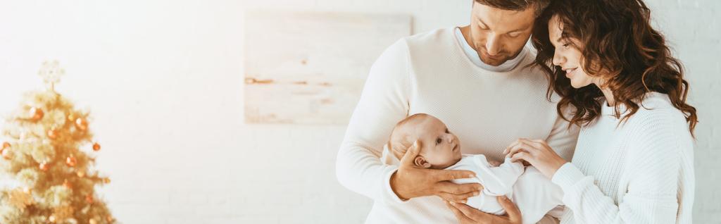 panoramic shot of happy woman standing near husband holding adorable baby - Photo, Image