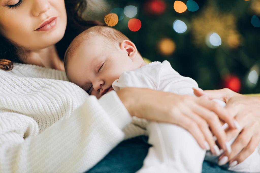 Ausgeschnittene Ansicht einer jungen Mutter mit schlafendem Baby - Foto, Bild