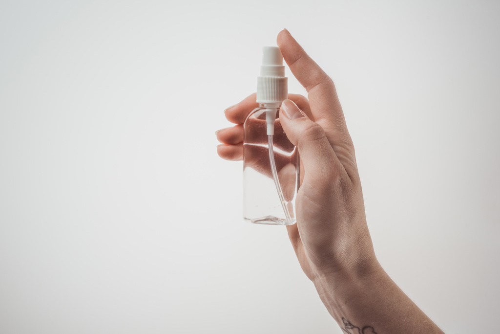 vista ritagliata di donna bottiglia di tenuta con liquido su sfondo bianco
  - Foto, immagini